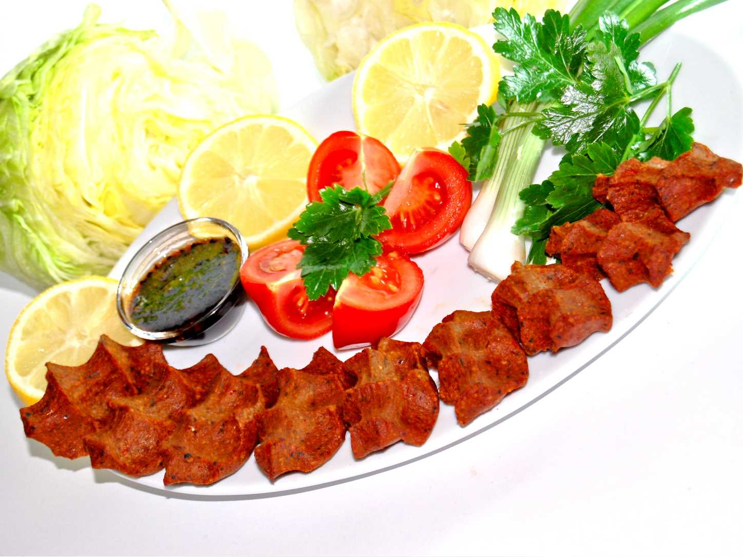Etsiz çiğköfte, iceberg marul ve limon eşliğinde servis edilen meze seçeneği.