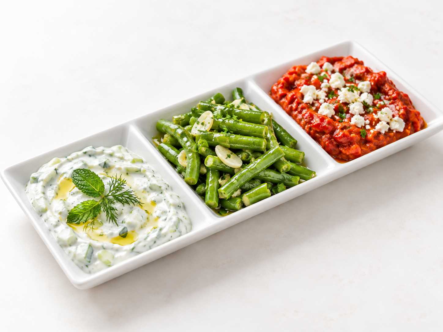 Cacık, sarımsaklı zeytinyağlı börülce salatası ve feta peynirli acılı ajvardan oluşan meze tabağı.