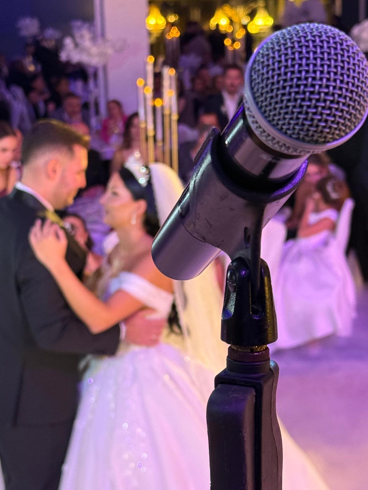 Düğün gecesinde sahne mikrofonunun arkasında dans eden gelin ve damat
