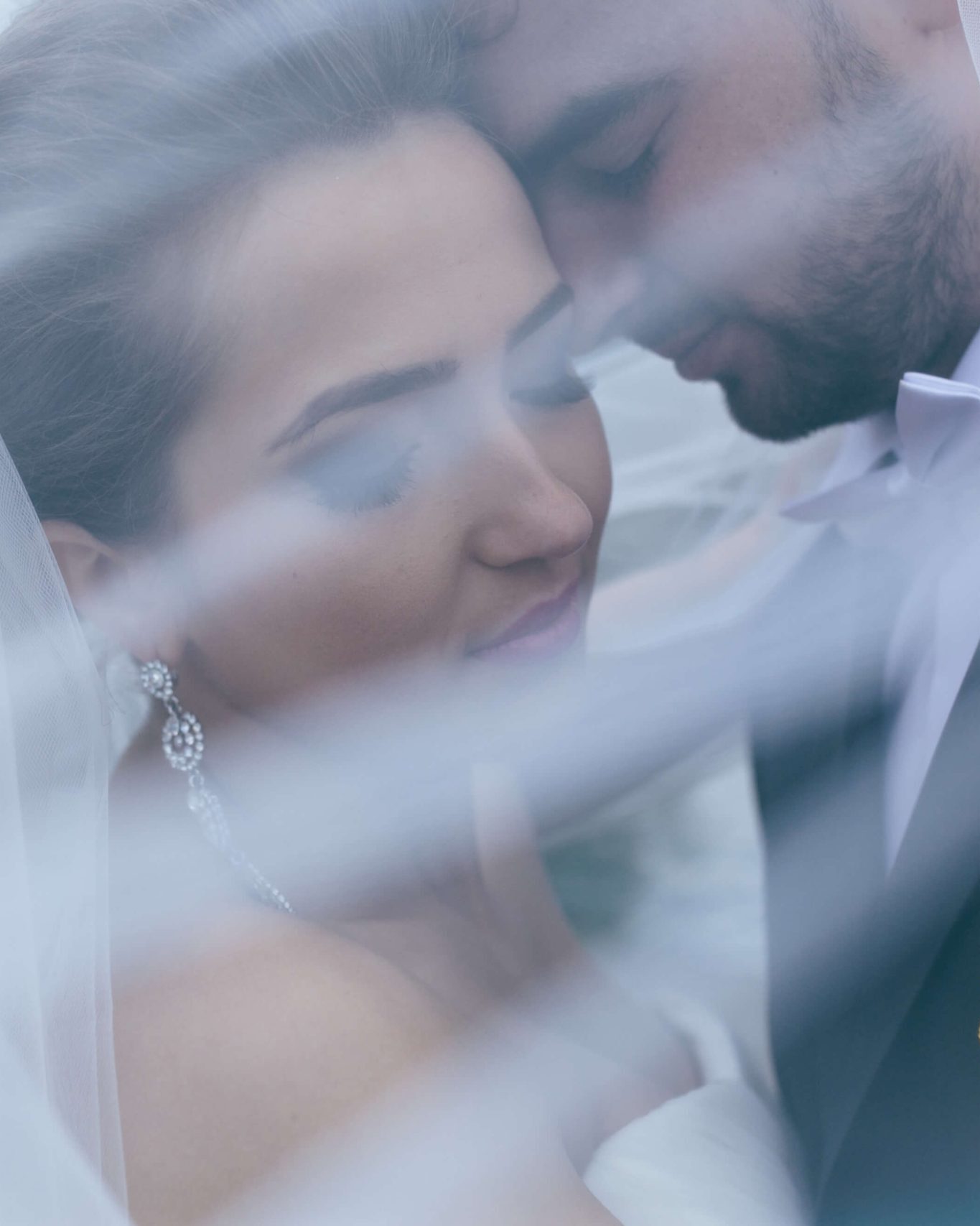 Dış çekimde duvak altında yakın planda gelin ve damat